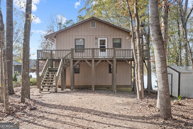 back of property featuring a wooden deck and a storage shed