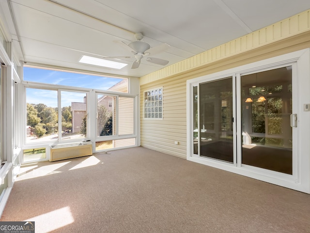 unfurnished sunroom featuring a wall mounted AC and ceiling fan