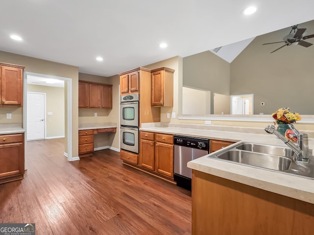 kitchen featuring sink, dark wood-type flooring, stainless steel appliances, vaulted ceiling, and built in desk