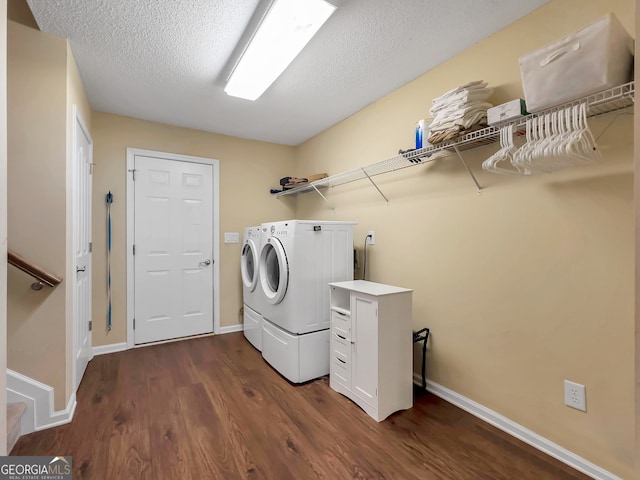 laundry area with dark hardwood / wood-style flooring, a textured ceiling, and washing machine and clothes dryer