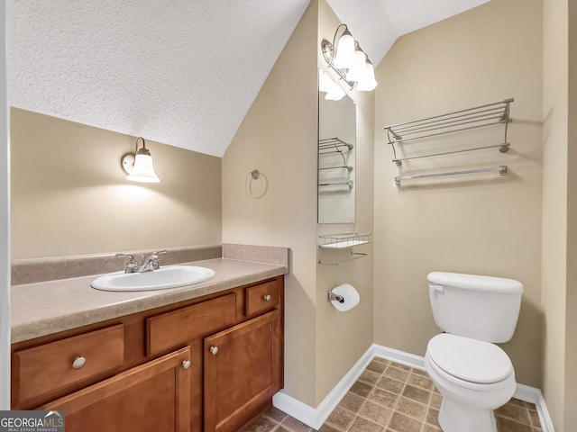 bathroom featuring tile patterned floors, vanity, vaulted ceiling, and toilet