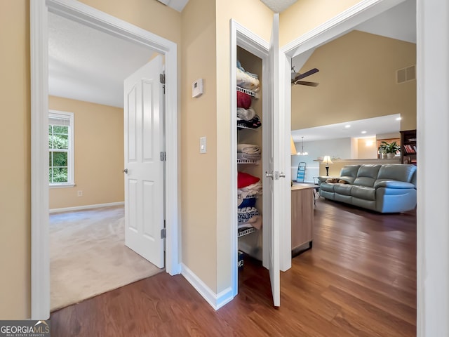 corridor featuring dark hardwood / wood-style flooring and lofted ceiling