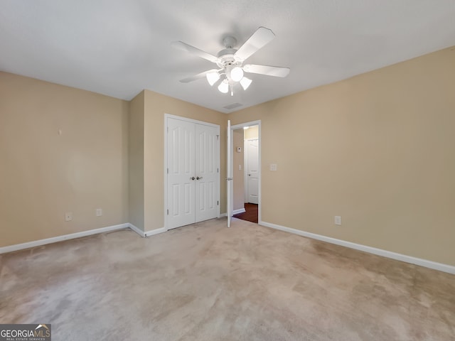 unfurnished bedroom with ceiling fan, a closet, and light carpet