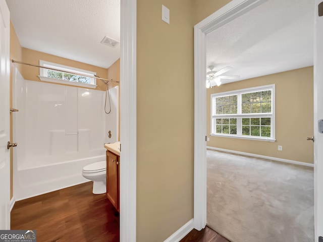 full bathroom with vanity, shower / washtub combination, ceiling fan, hardwood / wood-style floors, and toilet