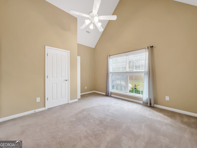 unfurnished room with ceiling fan, light colored carpet, and high vaulted ceiling