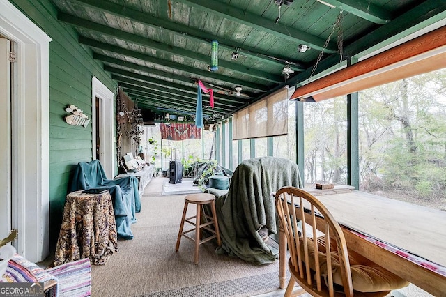 sunroom / solarium featuring vaulted ceiling with beams