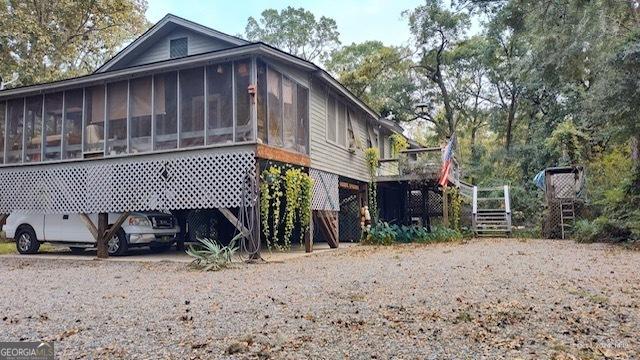 view of side of home featuring a sunroom and a carport