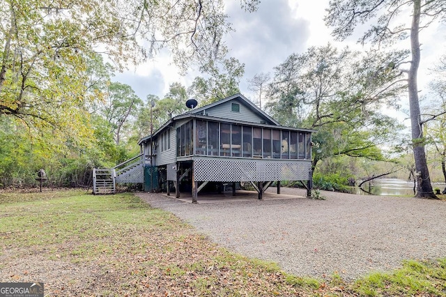 rear view of property with a sunroom and a lawn