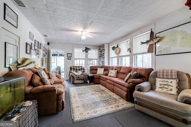 living room with a textured ceiling, carpet floors, plenty of natural light, and ceiling fan