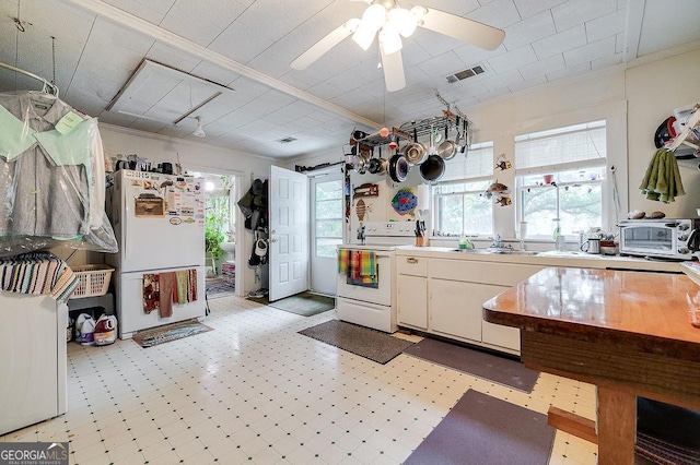 kitchen with ornamental molding, white appliances, ceiling fan, sink, and white cabinets