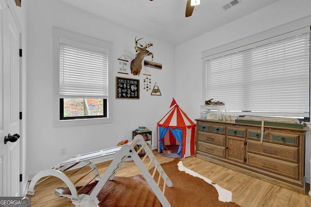 game room with ceiling fan and light wood-type flooring