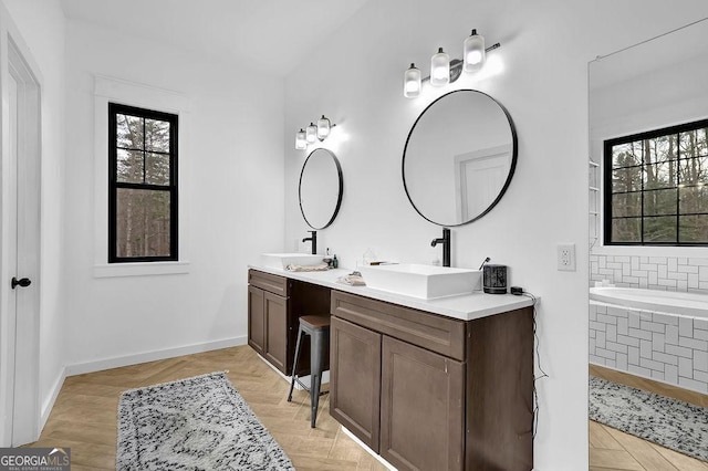 bathroom with vanity, a bath, and parquet floors