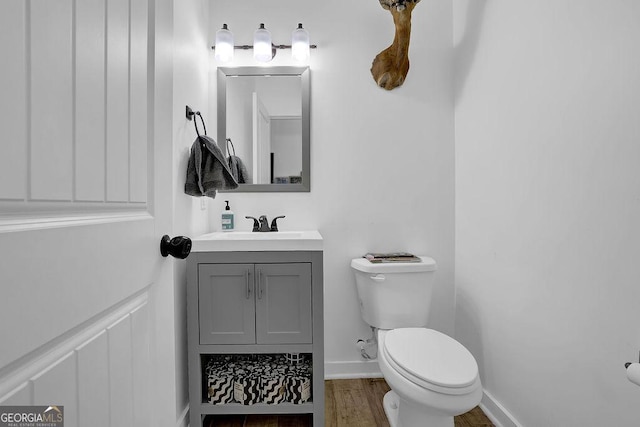 bathroom featuring vanity, toilet, and hardwood / wood-style floors