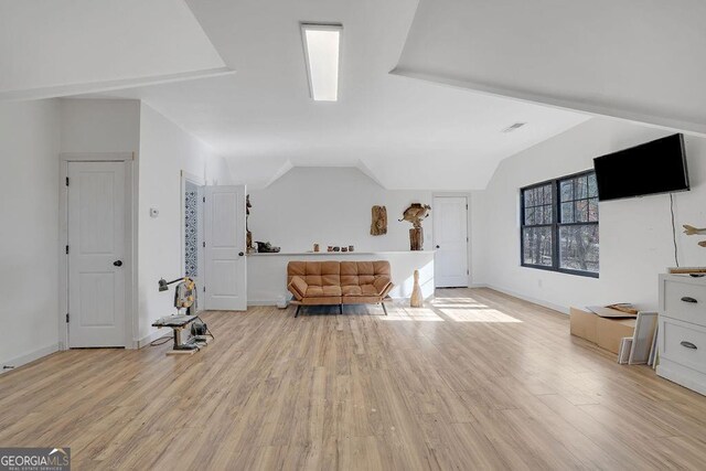 bedroom with vaulted ceiling and light hardwood / wood-style flooring