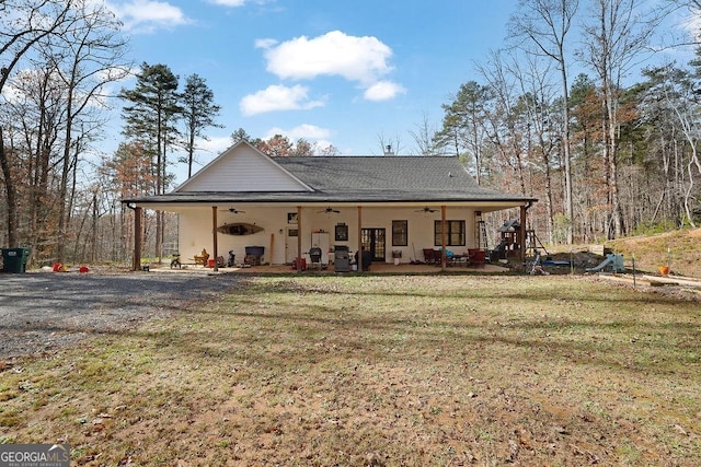 rear view of property with a patio, a yard, and ceiling fan