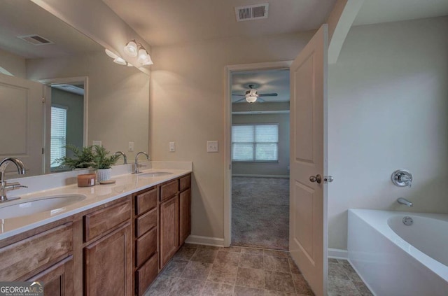 bathroom featuring vanity, ceiling fan, and a tub