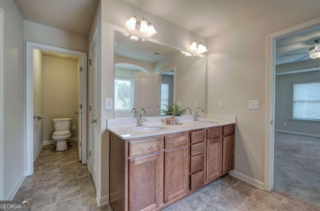 bathroom featuring vanity, toilet, and ceiling fan