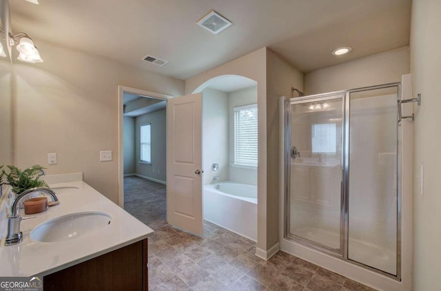 bathroom featuring vanity and independent shower and bath