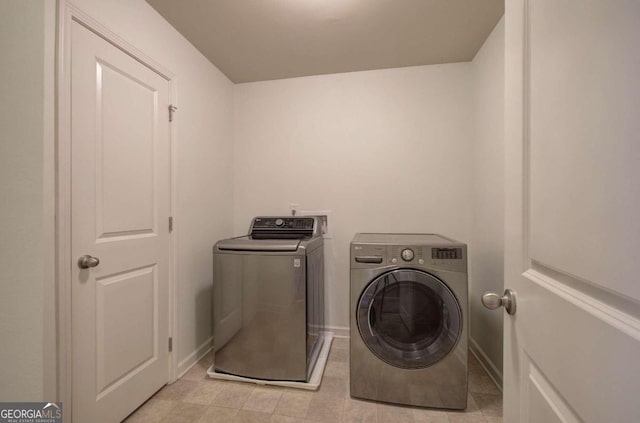 laundry room with light tile patterned flooring and washing machine and dryer