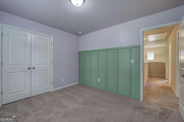 unfurnished bedroom with light colored carpet and a closet