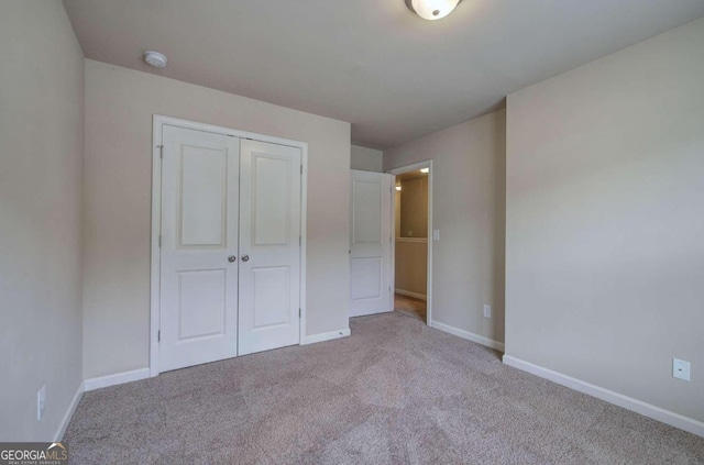 unfurnished bedroom with a closet and light colored carpet