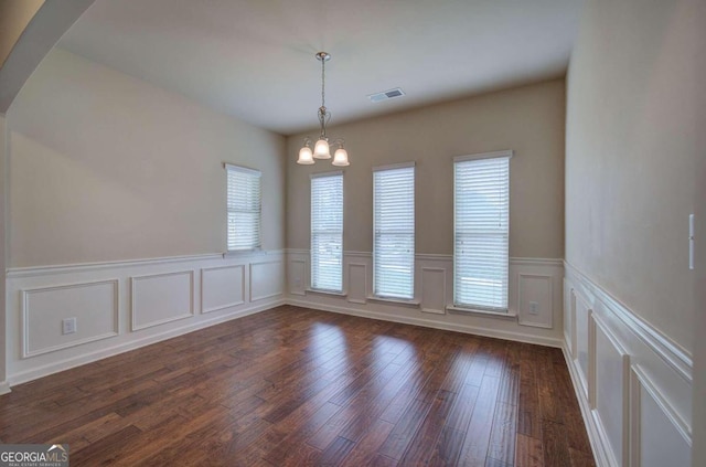 unfurnished dining area featuring dark hardwood / wood-style flooring and a notable chandelier