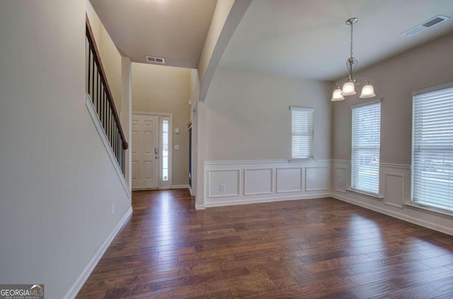 foyer entrance featuring dark wood-type flooring and an inviting chandelier