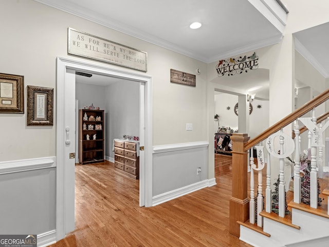 hall featuring stairs, crown molding, baseboards, and wood finished floors