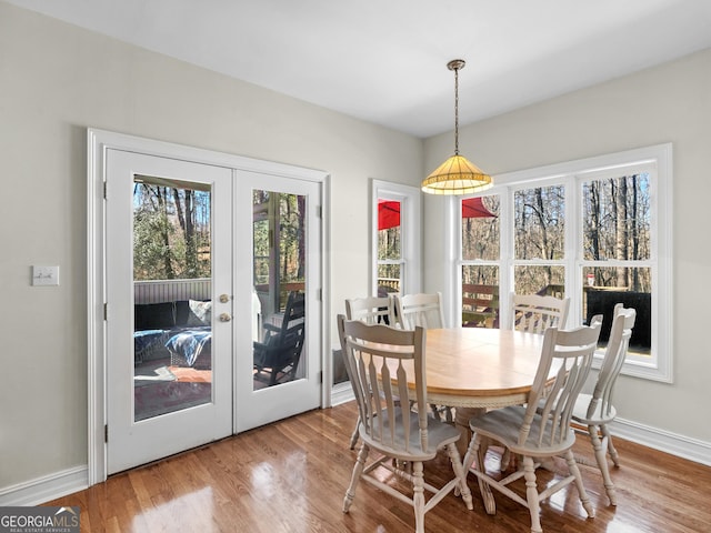 dining room with baseboards, wood finished floors, and french doors