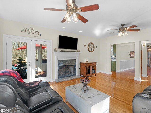 living room featuring french doors, ceiling fan, and light hardwood / wood-style flooring