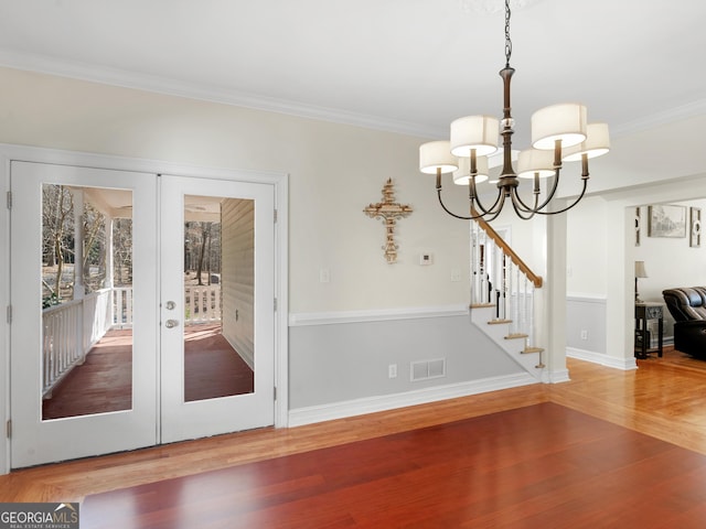 interior space with crown molding, stairway, wood finished floors, and french doors