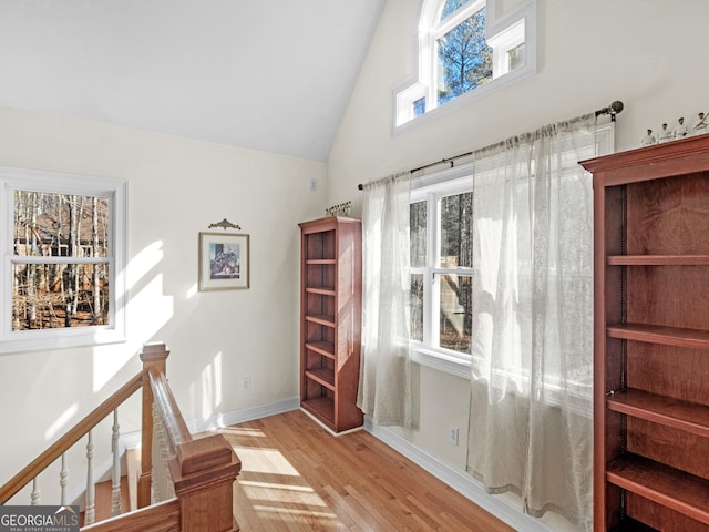 bonus room with high vaulted ceiling, wood finished floors, and baseboards