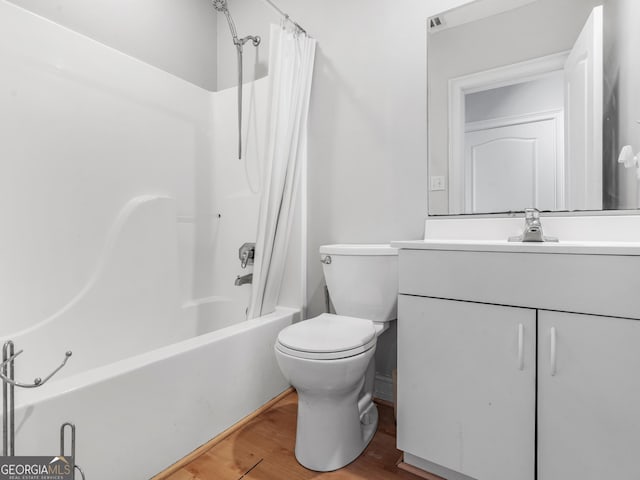 full bathroom featuring hardwood / wood-style flooring, vanity, shower / tub combo, and toilet