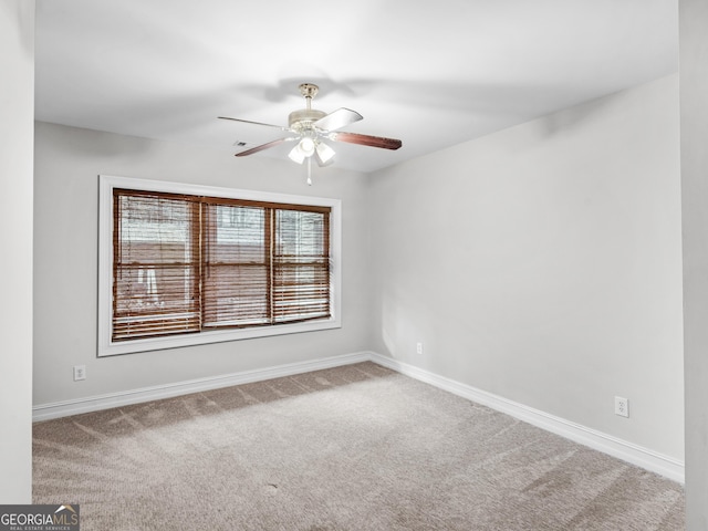 carpeted spare room featuring ceiling fan