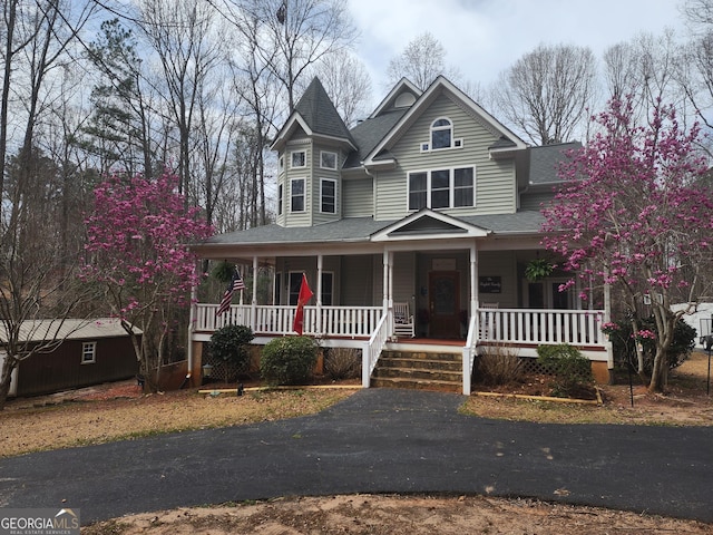 victorian house with a shingled roof and a porch