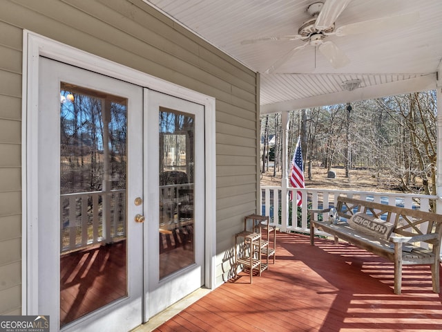 wooden terrace with a ceiling fan and french doors