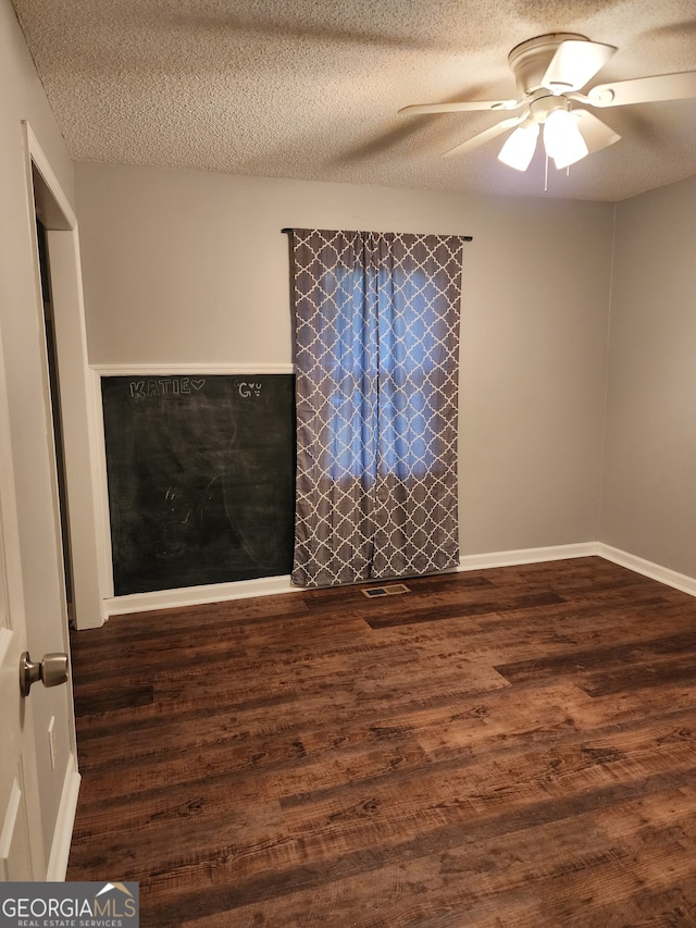 spare room with dark hardwood / wood-style flooring, a textured ceiling, and ceiling fan