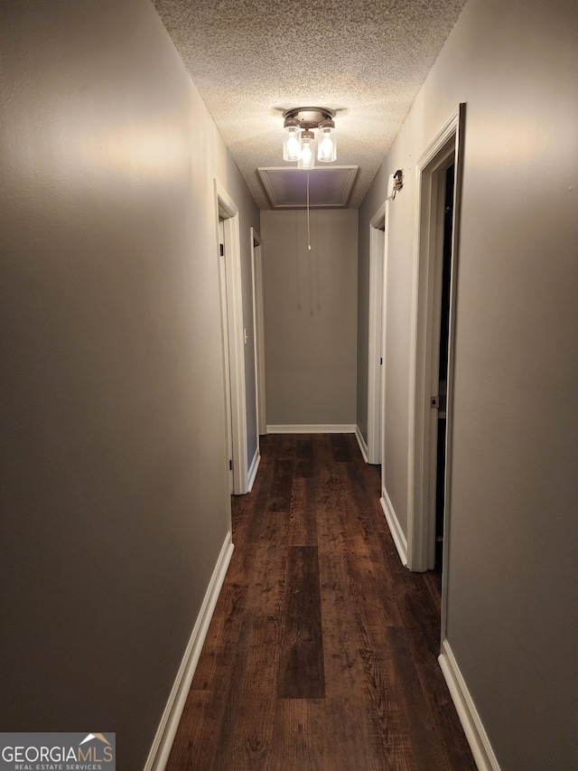 hallway with dark hardwood / wood-style flooring and a textured ceiling