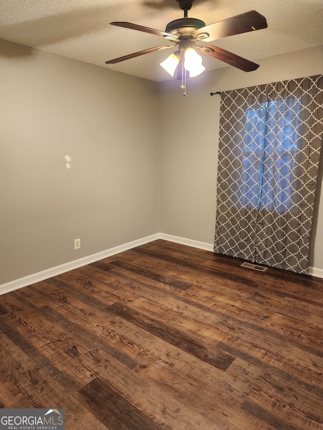 spare room featuring ceiling fan, dark hardwood / wood-style floors, and a textured ceiling