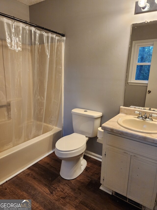 full bathroom featuring wood-type flooring, vanity, toilet, and shower / bath combination with curtain