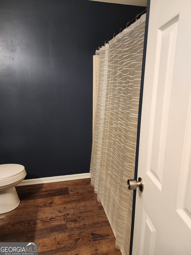 bathroom featuring wood-type flooring and toilet