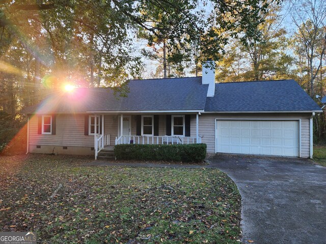 single story home featuring covered porch and a garage