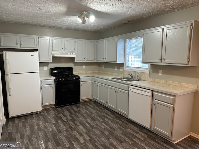 kitchen with sink, white cabinets, dark hardwood / wood-style floors, and white appliances