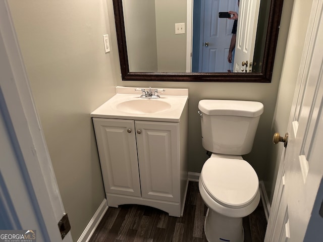 bathroom with hardwood / wood-style flooring, vanity, and toilet