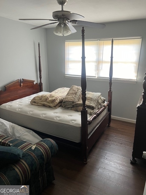 bedroom featuring multiple windows, dark hardwood / wood-style floors, and ceiling fan