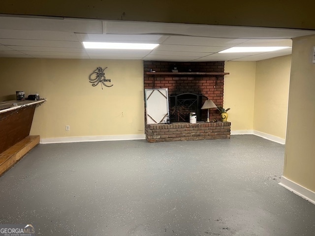 basement with a fireplace and a paneled ceiling