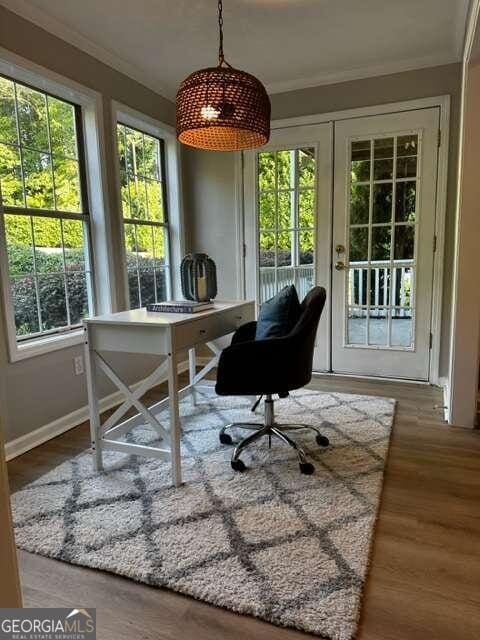 office with plenty of natural light, wood-type flooring, ornamental molding, and french doors