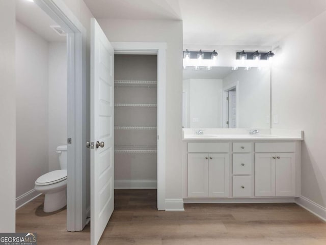 bathroom featuring toilet, vanity, and hardwood / wood-style flooring