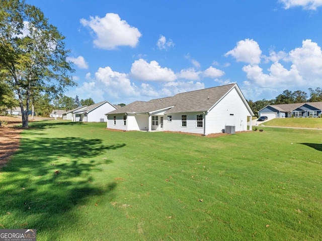 back of house with a lawn and central air condition unit