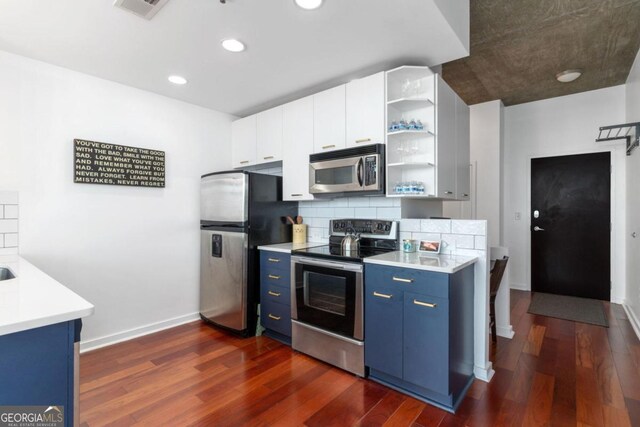 kitchen with blue cabinetry, tasteful backsplash, appliances with stainless steel finishes, dark hardwood / wood-style flooring, and white cabinets